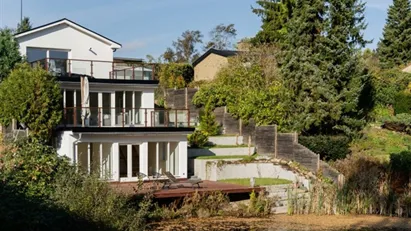 Totalrenoveret villa i tre plan med terrasser og privat sø